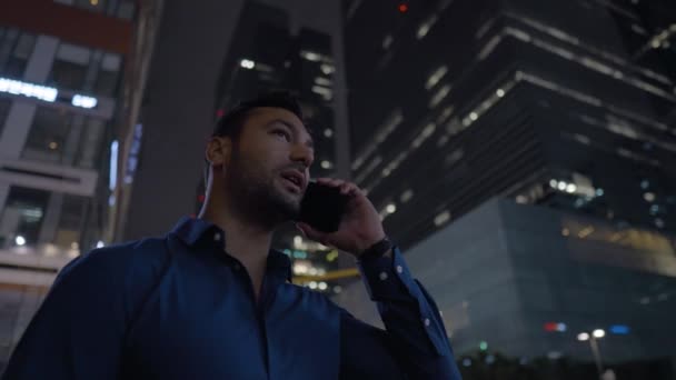 Young Businessman Having Phone Talk While Standing High Rise Skyscrapers — Vídeo de stock