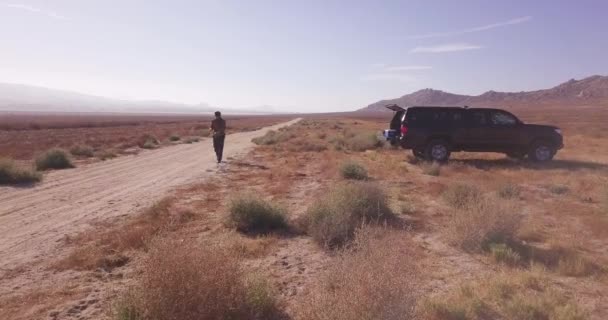 Joven Prepara Para Lanzar Dron Consumo Sandy Desert Road Path — Vídeos de Stock
