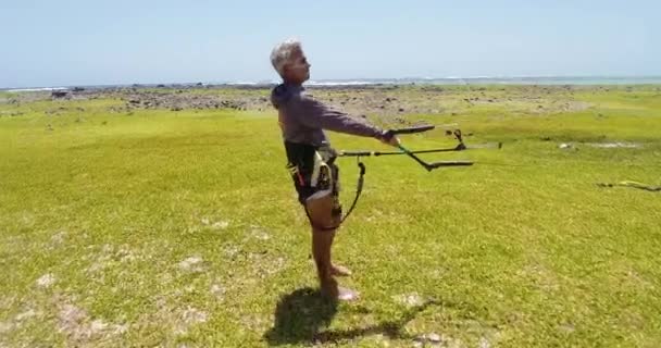 Gray Haired Man Holding Lifts Kite Beach Grass Kitesurf Activity — стоковое видео