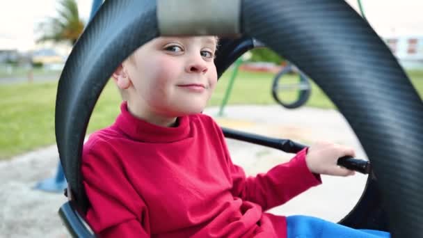 Portrait Cute Boy Making Faces Camera While Swings Playground — Αρχείο Βίντεο