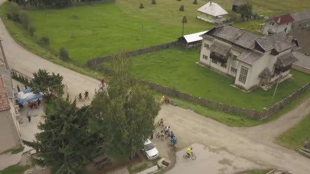 Aerial Shot Panning Cyclists Departing Rural Town Race Mountain Romania — Stockvideo