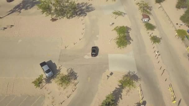 Aerial View Black Car Driving Parking Lot Sandy Beach Campground — Stock videók
