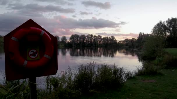 Slow Panning Shot Life Ring Lake Sunset — стоковое видео