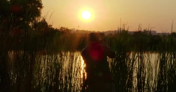 Φωτογράφος Λήψη Φωτογραφιών Του Ηλιοβασιλέματος Στη Λίμνη — Αρχείο Βίντεο