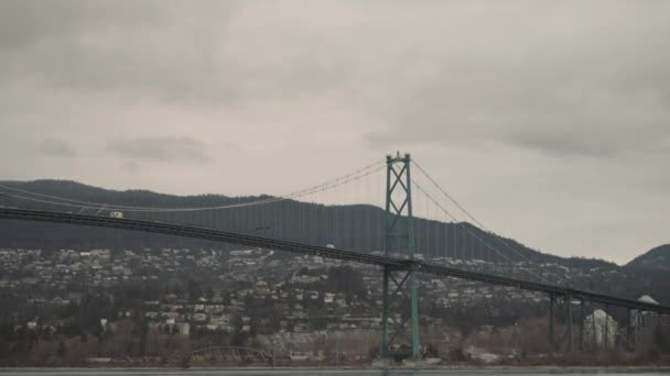 Wide Panning Shot Lions Gate Bridge Snow Packed Mountains Cloudy — 图库视频影像