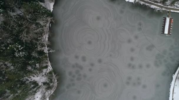Повітряний Постріл Замерзлого Озера Невеликим Озерним Будинком Оточенні Лісу Взимку — стокове відео