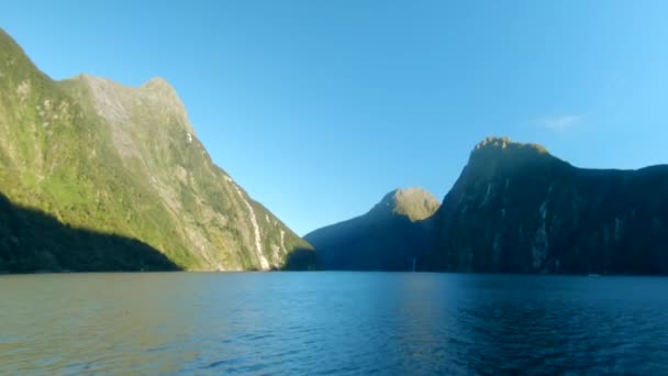 ニュージーランドのミルフォードサウンドにある山の崖に日の出の間に初めて撮影されました — ストック動画