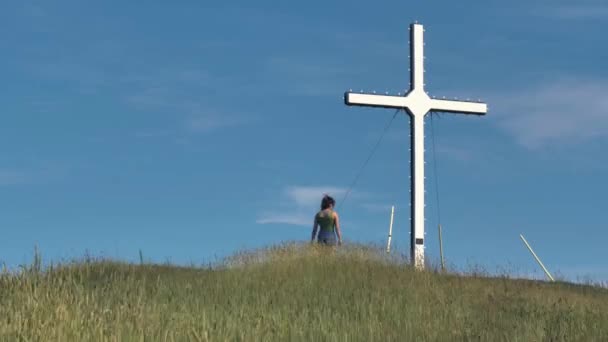 Woman Walks Large White Cross Top Hill Strong Breeze Blows — Stock Video