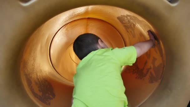 Little Boy Bright Green Shirt Slides Backwards Yellow Tube Slide — Stockvideo