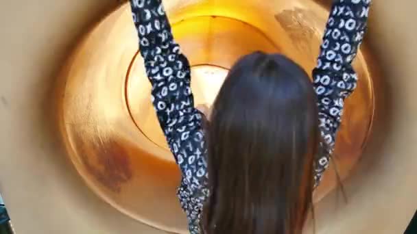 女の子とともに長い茶色の髪スライドダウン黄色チューブスライド — ストック動画