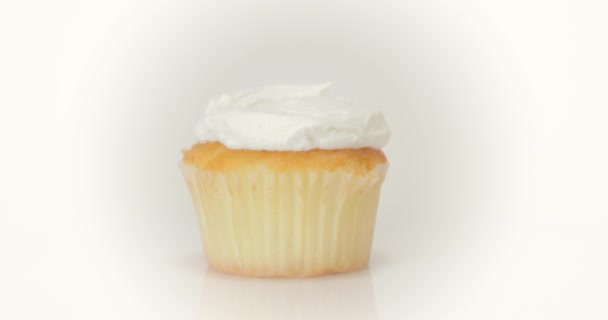 バニラカップケーキはきれいな白い背景で回転します お祝いのために上に霜 — ストック動画