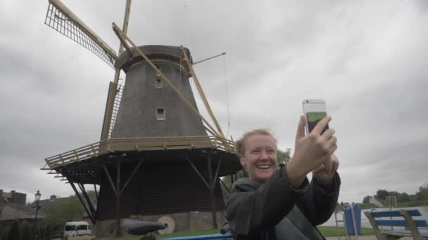 Jonge Vrouw Neemt Een Selfie Met Een Windmolen Achtergrond — Stockvideo