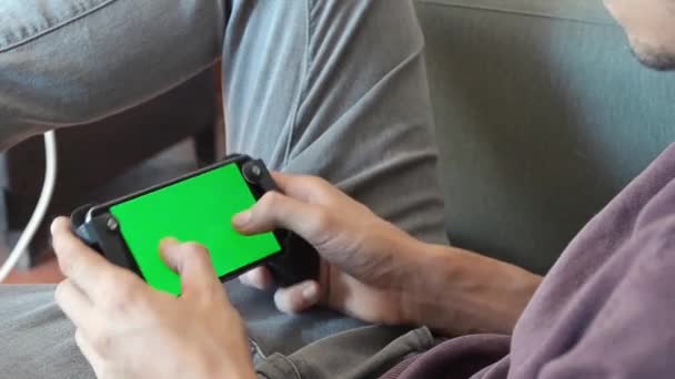 Молодий Чоловік Імітує Розблокування Мобільної Гри Зеленим Екраном Кольорового Ключа — стокове відео