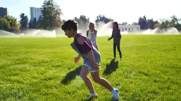 Kurzhaariges Mädchen Latzhosen Fährt Wagenräder Einem Park Voller Sprinkler — Stockvideo