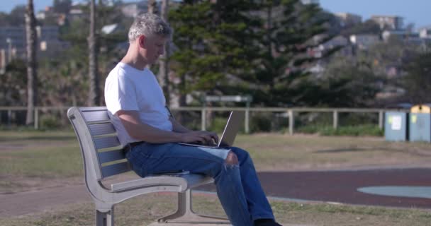 Mature Man Working Outdoors Typing Laptop Checking Smartphone Sitting Metal — Video