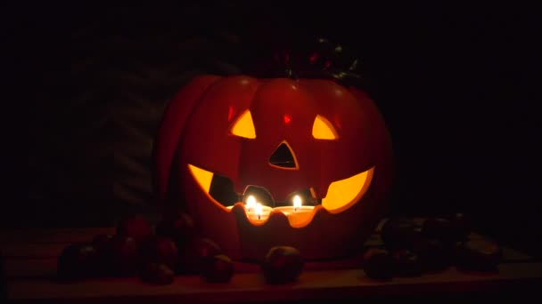 Halloween Kürbis Vor Dunklem Hintergrund Mit Kastanien Beleuchtet Von Kerzen — Stockvideo