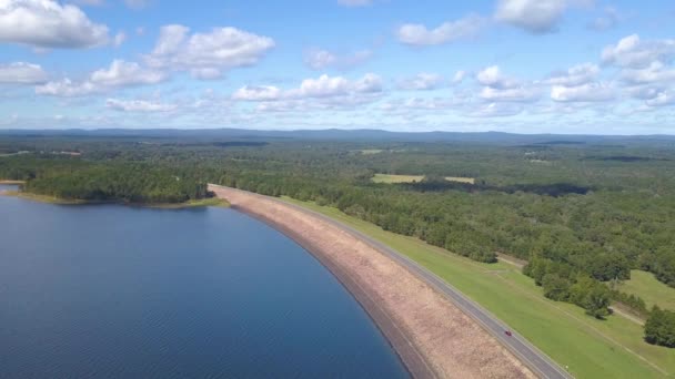 Cars Driving Lake Dam Surrounded Forest Blue Water Distant Mountains — Stock Video