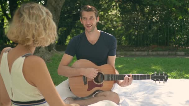 Man Plays Romantic Song His Guitar Woman Outdoor Picnic Slow — 图库视频影像