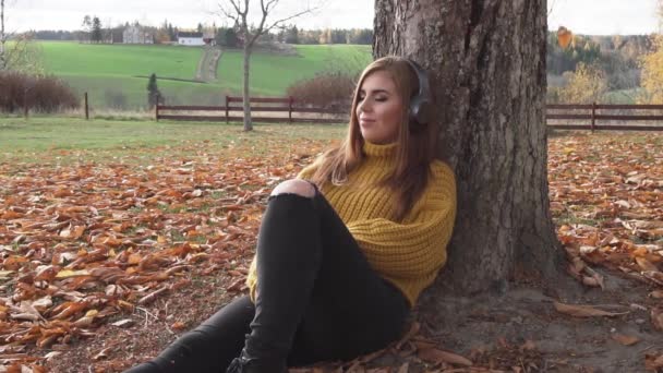 Dospělá Dívka Sedí Pod Stromem Poslouchá Audio Knihy Nebo Hudbu — Stock video