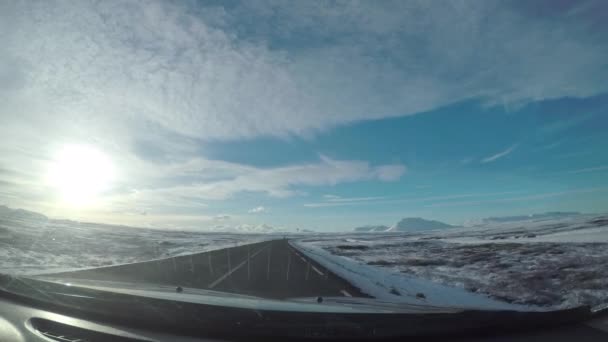아이슬란드의 눈덮인 산들을 통과하는 차들을 지나가는 도로의 유리에서 바라본 — 비디오
