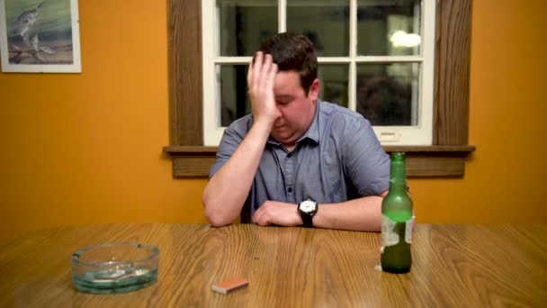 男人在餐桌边喝酒 用手梳理头发 — 图库视频影像