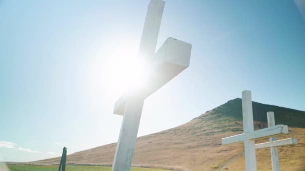 在冰岛小山附近的白色十字架后面 背景是美丽的太阳耀斑 — 图库视频影像