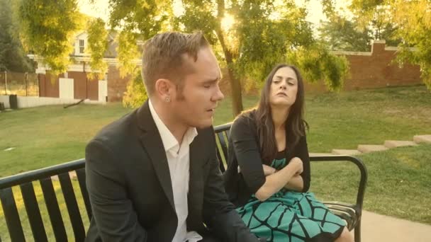 男は彼女が公園のベンチで絶望に沈むと女性と主張します — ストック動画
