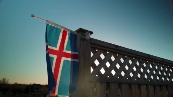 Small Frayed Icelandic Flag Backyard Fence Flapping Sunset — Stock Video