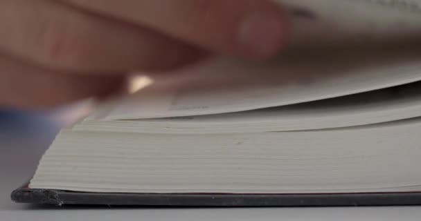 Ein Mann Blättert Mit Den Fingern Einem Buch — Stockvideo