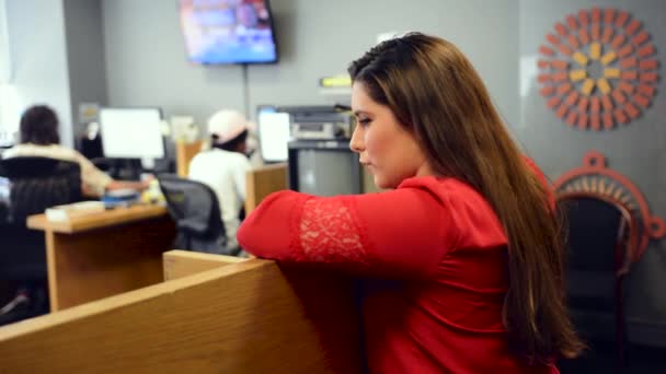 Woman Red Shirt Leans Cubical Observes Coworkers — Stockvideo