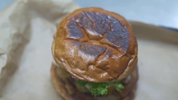 在餐馆里 一个大牙签被放在一个好吃的汉堡包的顶部 作为最后的触摸 — 图库视频影像