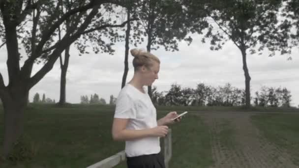 Zbliżenie Młodej Kobiety Jedzącej Bawiącej Się Telefonem Holenderskiej Wsi — Wideo stockowe