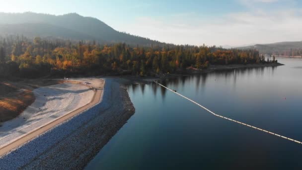 Aerial Shot Dam Blue Alpine Lake Surrounded Pine Trees Mountains — 비디오