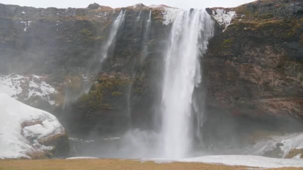 Static Shot Water Streaming Snowy Ground Seljalandfoss Waterfall Cloudy Autumn — Wideo stockowe