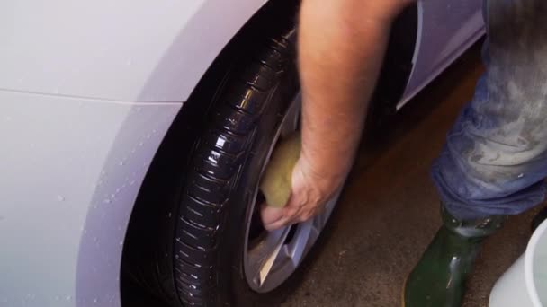 瑞典卡沃什 一辆白色的Suv牌汽车的工人喷水和清洗轮缘 — 图库视频影像