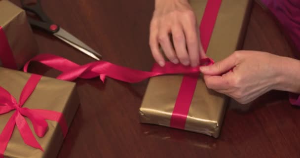 Fechar Mãos Amarrando Fita Vermelha Presentes Natal — Vídeo de Stock