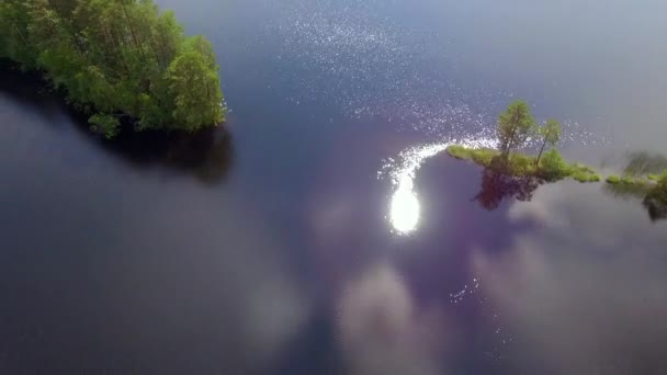 在芬兰的一个森林湖中 美丽的河岸正在拍摄一个小斗篷的无人驾驶视频 阳光从湖面上发出美丽的光芒 July 2018 — 图库视频影像