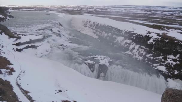 アイスランドの南海岸の暗い曇り空と雪に覆われた秋の日には 静的で広大なガルフフォスの滝の峡谷が撮影されました — ストック動画