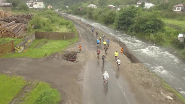 Wide Aerial Shot Group Mountain Bikers Riding Rain Mud Alongside — 图库视频影像