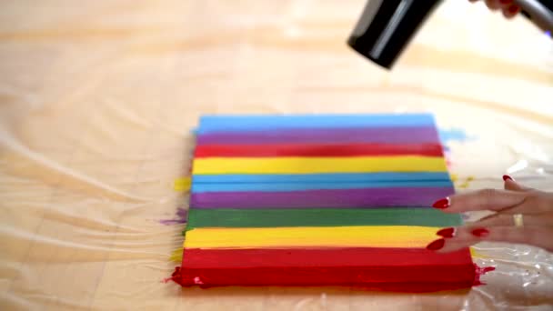 Uma Mulher Sopra Secando Uma Pintura Listras Coloridas Uma Tela — Vídeo de Stock