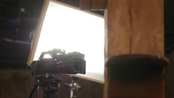 Studio Κάμερα Τρίποδο Μπροστά Από Επαγγελματικά Φώτα Στούντιο — Αρχείο Βίντεο