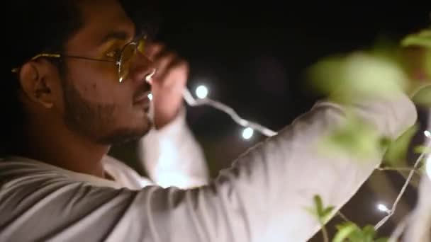 Šťastný Mladý Samec Zdobí Rostliny Barevnými Led Světla Vánoce Diwali — Stock video