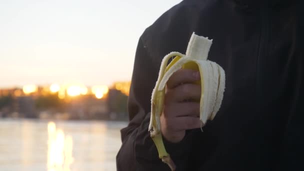 Close Shot Man Holding Half Eaten Banana Panning His Face — Stock Video