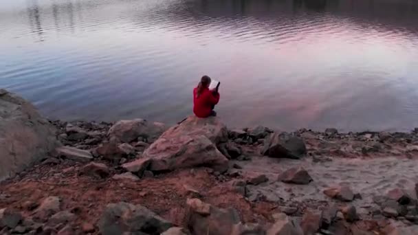 Aerial Shot Girl Reading Rock Lake Sunset — Vídeos de Stock