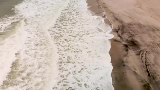砂浜に打ち寄せる波を後ろから見下ろす空中撮影 — ストック動画