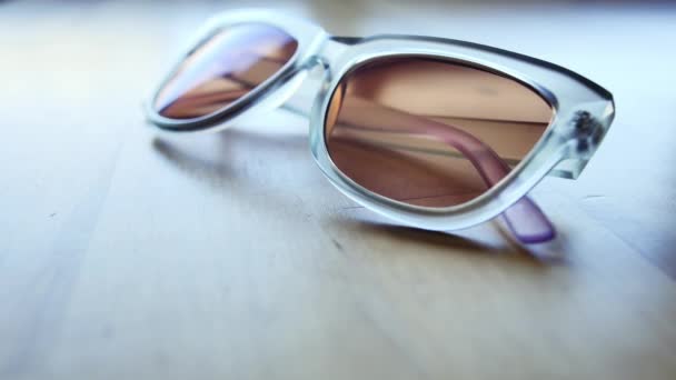 Extreme Close Blue Cat Eye Sunglasses Being Picked Table — 图库视频影像