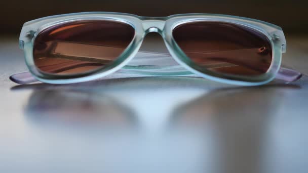 Blue Sunglasses Sitting Slightly Reflective Wood Table — Stock videók