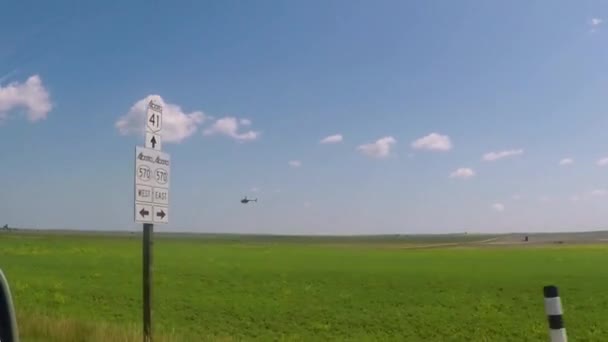 Helicopter Flying Green Grassy Field Filmed Car Driving Highway Blue — Stock video
