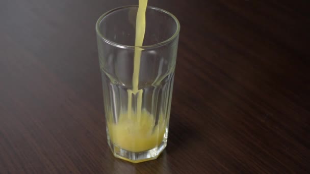 Pouring Botteled Orange Juice Tall Glass Wooden Table — Vídeo de stock