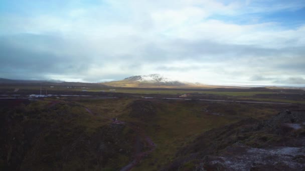 遠くの空の下のアイスランドの山遠くの車が通り過ぎる — ストック動画